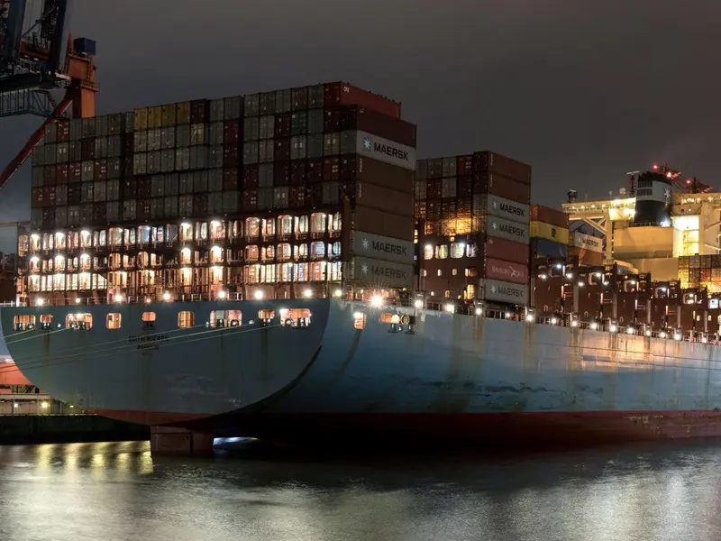 Container ship loaded with containers at a port, seen from the side
