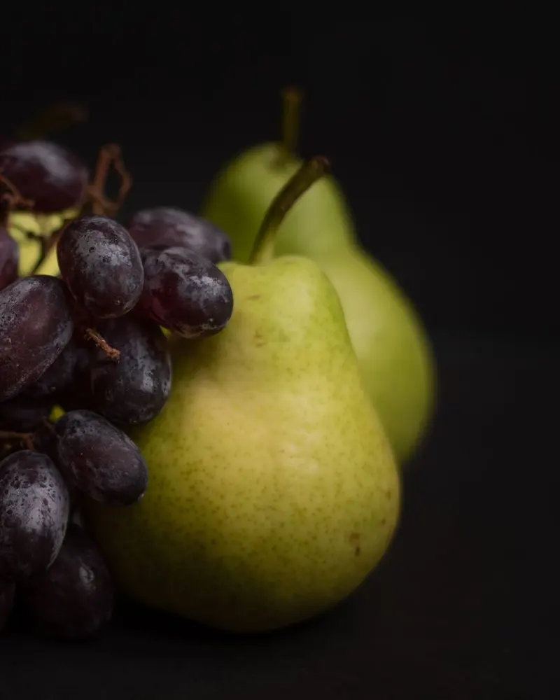 Grapes and pears on a dark background